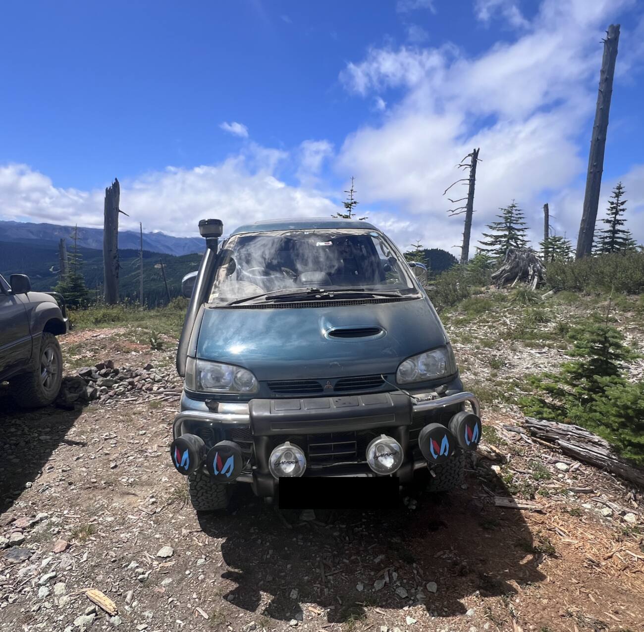 Front view of the Delica on a mountain trail, with light bar and off-road lights